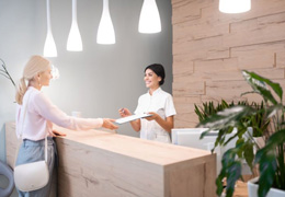 Dental patient filling out forms at front desk
