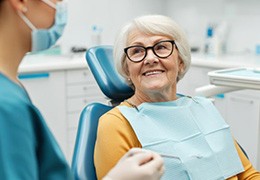 Smiling senior patient talking to dental team member