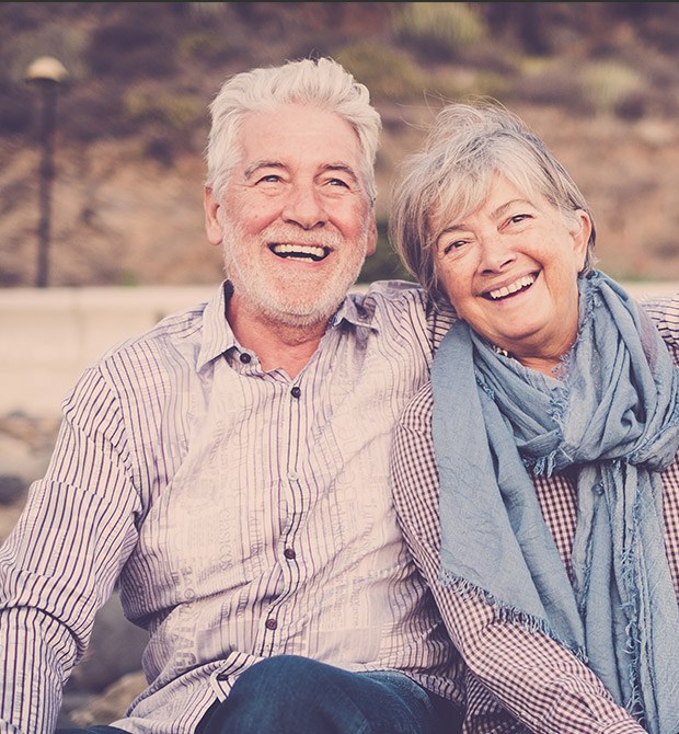 Older man and woman smiling outdoors