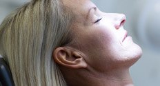 Relaxed woman with eyes closed in dental chair