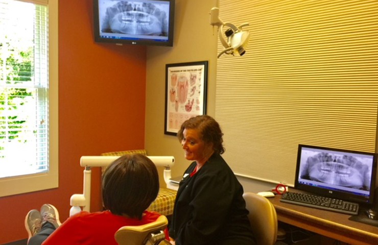 Dental team member and patient in exam room