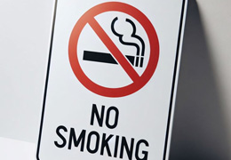 No smoking sign leaning against a wall