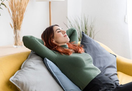 Woman leaning back on her sofa, resting