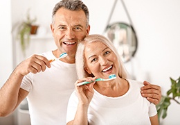Mature couple holding their toothbrushes