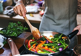 Person cooking a colorful vegetable dish