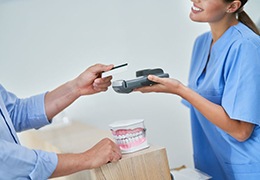 Dental team member accepting payment from patient