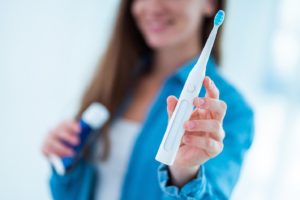 woman holding electric toothbrush