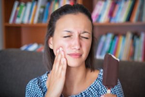 woman with dental sensitivity eating an ice cream bar