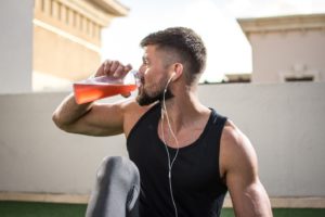 man sipping on sports drink to stay hydrated