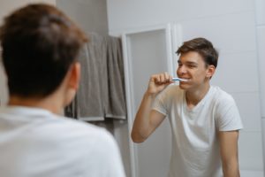Young man brushing teeth to prevent dental emergency