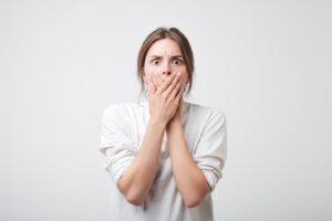 Woman covering mouth, concerned after losing dental filling