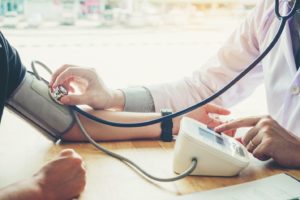 Medical professional using equipment to take patient’s blood pressure