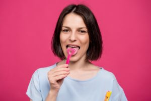 Smiling woman applying advice on how to clean her tongue