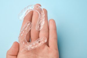 Two clear aligners resting on person’s hand