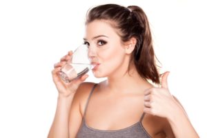 Woman drinking water, making thumbs up sign