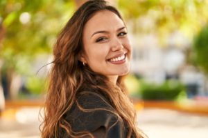 Woman with beautiful teeth smiling over her shoulder