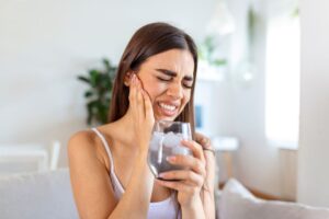 Woman cringing due to sensitive teeth
