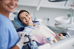 Happy dental patient in treatment chair 